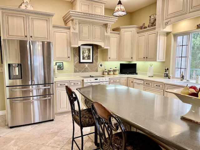 kitchen featuring backsplash, cream cabinets, and stainless steel fridge