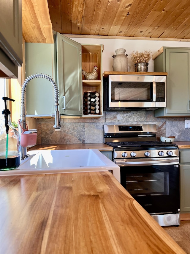 3705 Hope Way, Kettle Falls, WA 99141 - kitchen featuring appliances with stainless steel finishes, wooden ceiling, a sink, wooden counters, and decorative backsplash