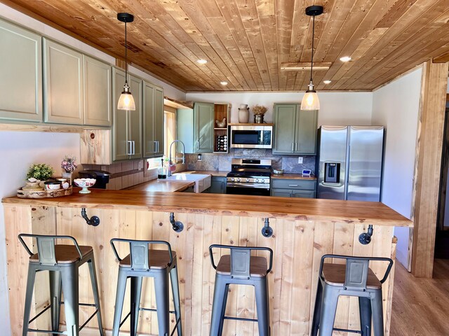 3705 Hope Way, Kettle Falls, WA 99141 - kitchen featuring stainless steel appliances, butcher block counters, wood ceiling, a sink, and a peninsula