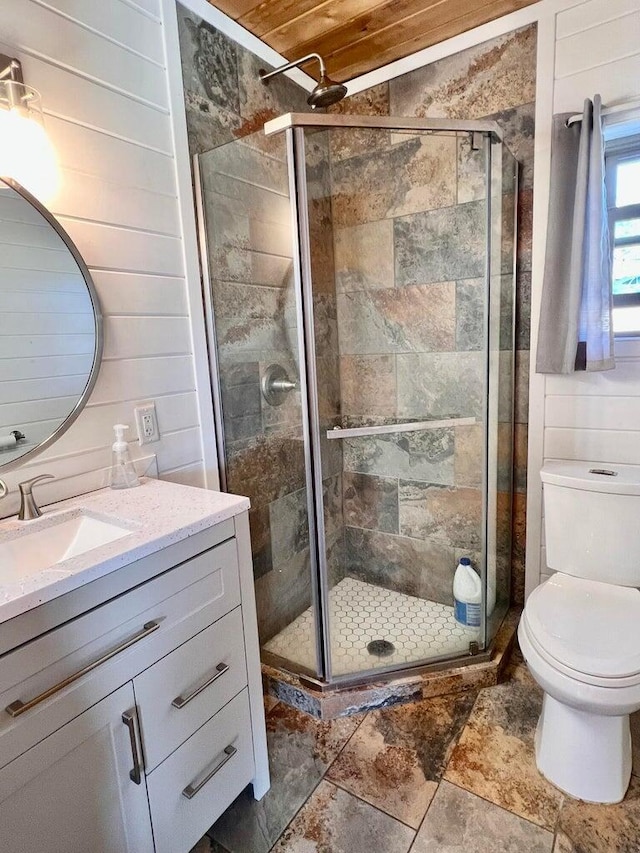 3705 Hope Way, Kettle Falls, WA 99141 - full bathroom with vanity, toilet, a shower stall, wood walls, and stone finish flooring