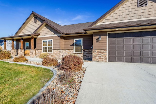 craftsman-style home featuring a porch, a garage, and a front lawn