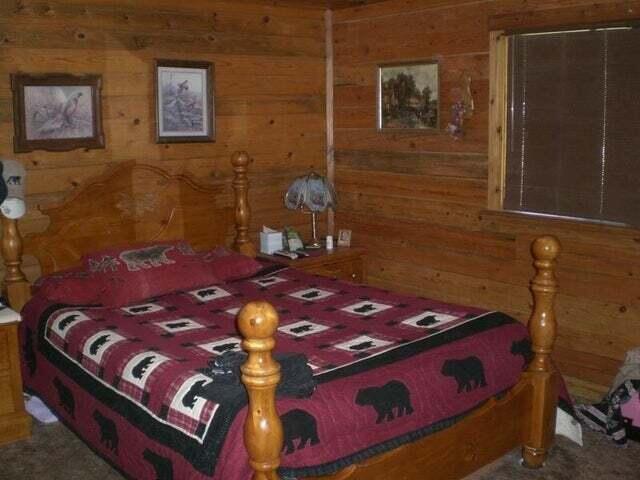 carpeted bedroom featuring wood walls