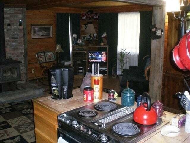 kitchen with stove, wood walls, and a wood stove