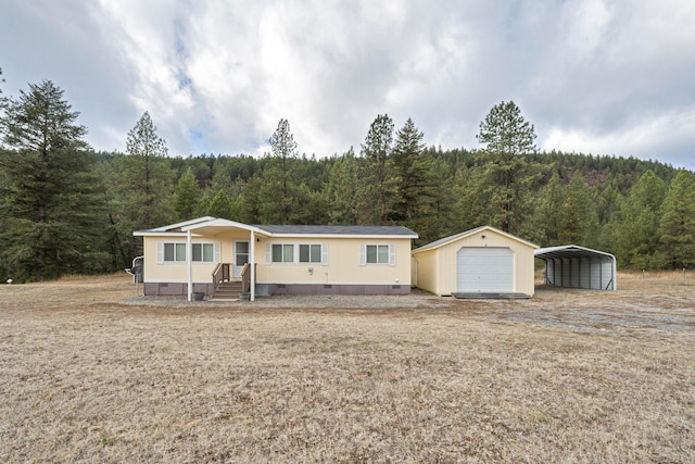 manufactured / mobile home with a carport and an outbuilding