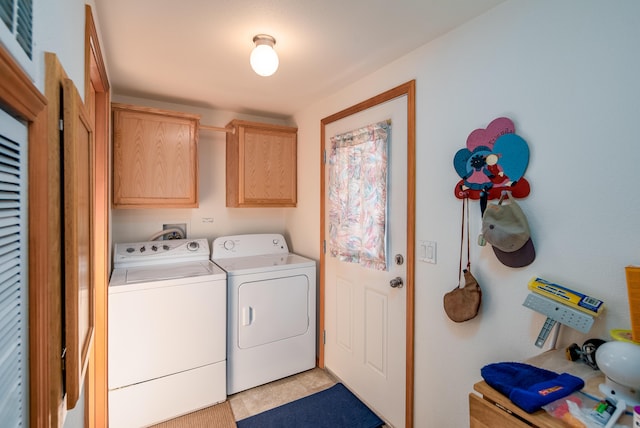 washroom featuring light tile patterned floors, cabinets, and washer and dryer