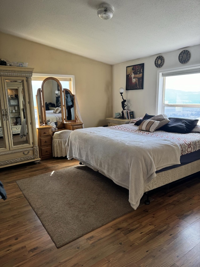 bedroom featuring dark hardwood / wood-style flooring and a textured ceiling