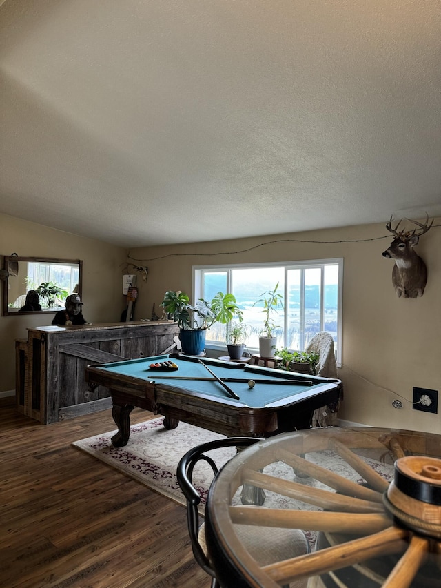 game room featuring hardwood / wood-style floors, a textured ceiling, billiards, and a healthy amount of sunlight