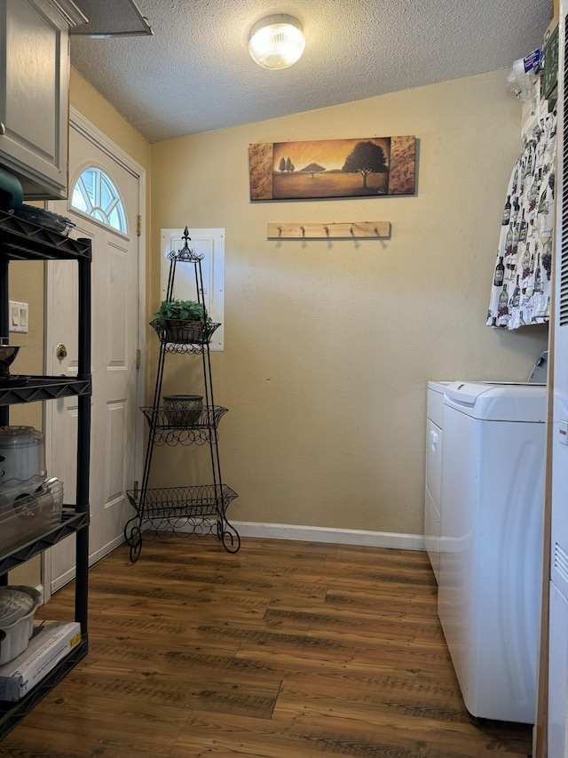 laundry area featuring independent washer and dryer, cabinets, dark hardwood / wood-style floors, and a textured ceiling