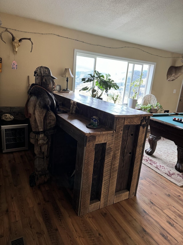 interior space featuring dark wood-type flooring, billiards, a healthy amount of sunlight, and a textured ceiling