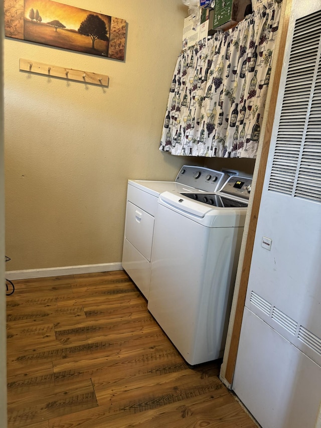 clothes washing area featuring dark wood-type flooring and washing machine and clothes dryer