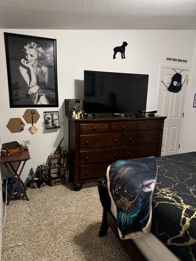 bedroom featuring a textured ceiling and carpet flooring