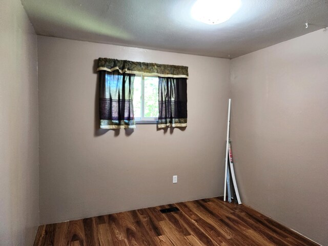 unfurnished room featuring dark wood-type flooring