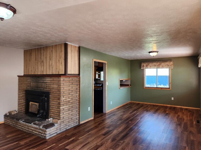 unfurnished living room featuring dark hardwood / wood-style flooring and a textured ceiling
