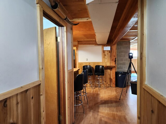 corridor with wooden walls and light hardwood / wood-style floors