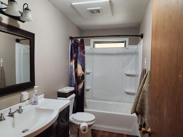 full bathroom featuring a textured ceiling, toilet, vanity, and shower / tub combo