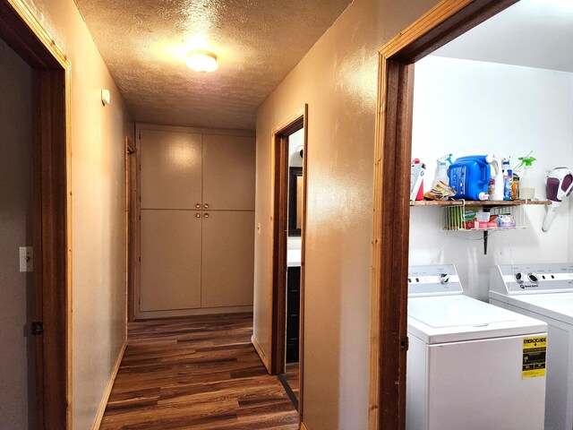 washroom with dark wood-type flooring, a textured ceiling, and washing machine and dryer