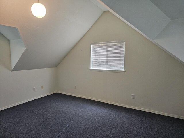 bonus room with vaulted ceiling and carpet