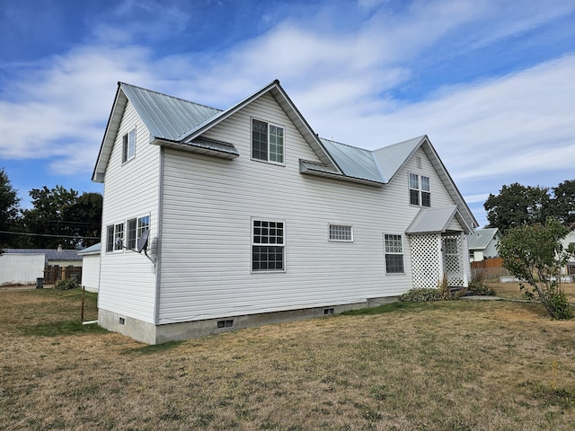 back of property featuring a lawn