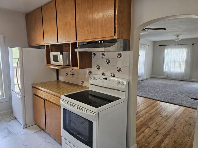 kitchen featuring backsplash and white appliances