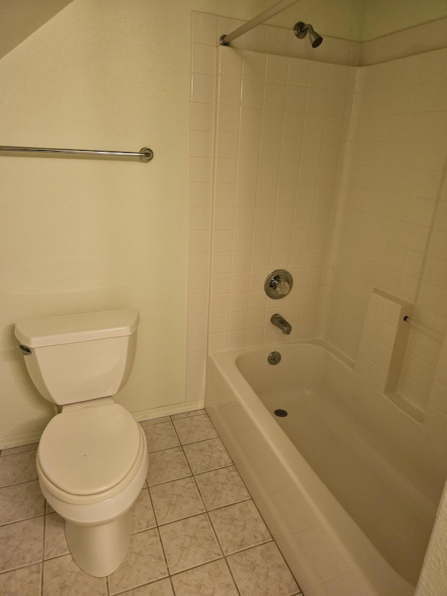 bathroom with tile patterned floors, toilet, and tiled shower / bath