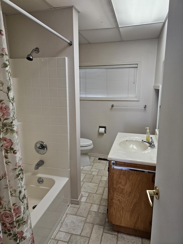 full bathroom featuring shower / bath combo with shower curtain, a paneled ceiling, toilet, and vanity