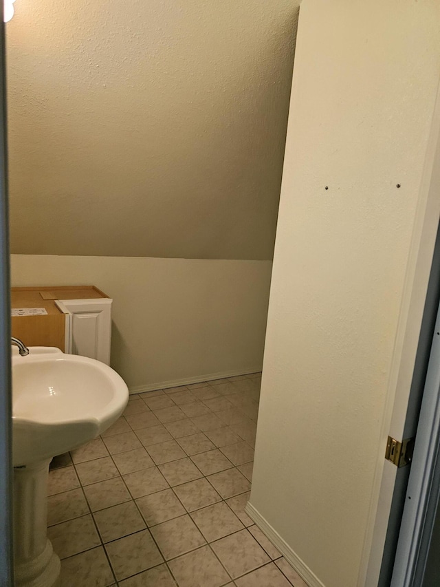 bathroom featuring vaulted ceiling and tile patterned flooring