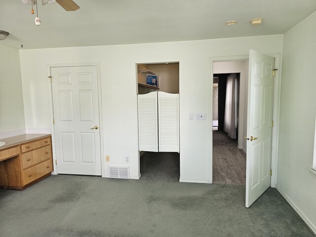 unfurnished bedroom featuring ceiling fan and dark carpet