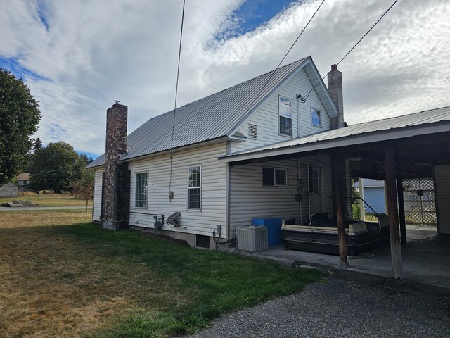 rear view of property featuring a yard and central AC