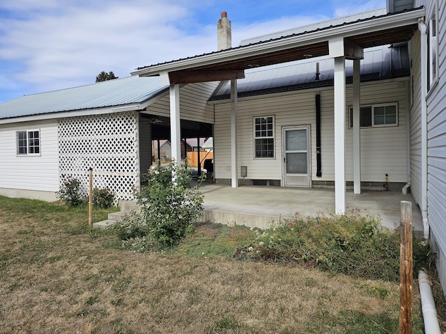 back of house featuring a lawn and a carport