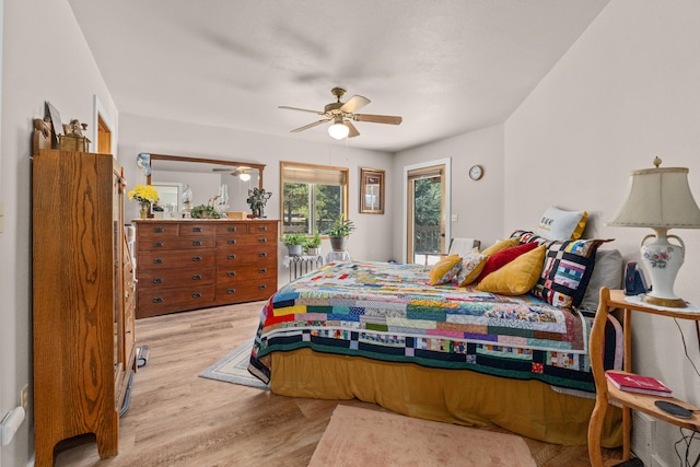 bedroom with access to outside, light wood-type flooring, and a ceiling fan