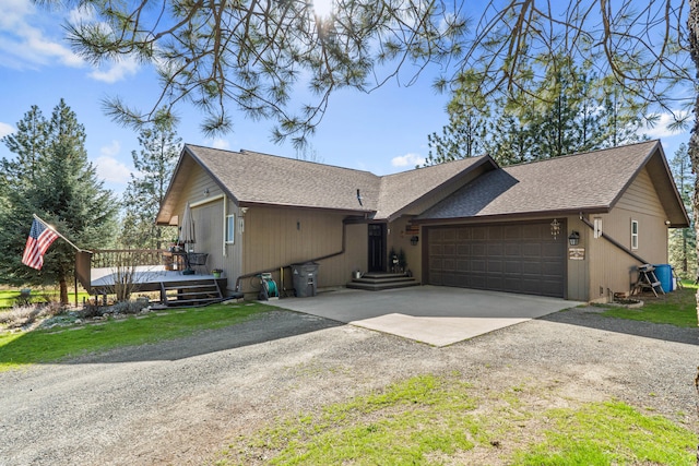 view of front of home with roof with shingles, driveway, a garage, and a wooden deck