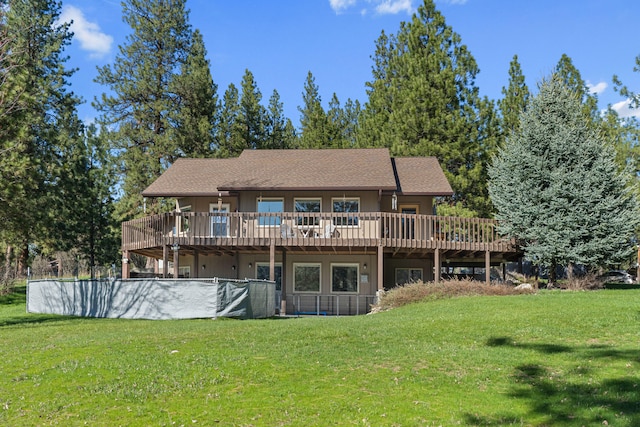 back of property featuring a wooden deck and a lawn