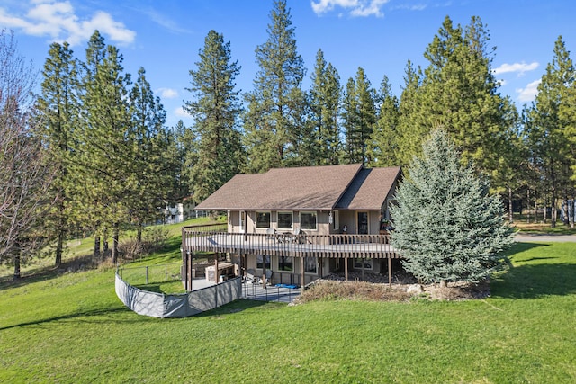 rear view of house with a patio area, a wooden deck, and a yard