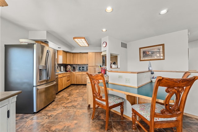 kitchen featuring decorative backsplash, stainless steel fridge, visible vents, and recessed lighting
