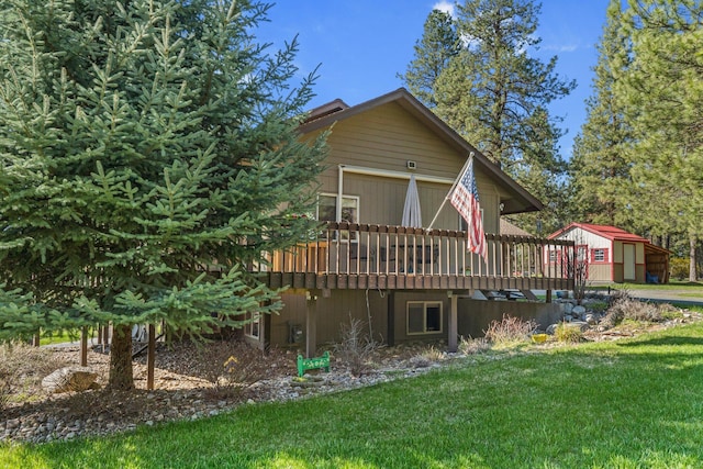 back of house with a yard, a wooden deck, and a garage