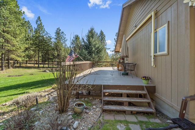 wooden deck featuring a lawn
