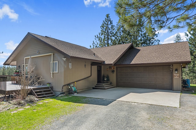 view of front of house with roof with shingles, a deck, a garage, and gravel driveway