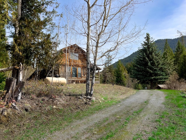 view of front of property with a mountain view and a wooded view