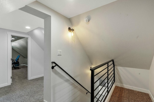 staircase featuring baseboards, vaulted ceiling, and carpet