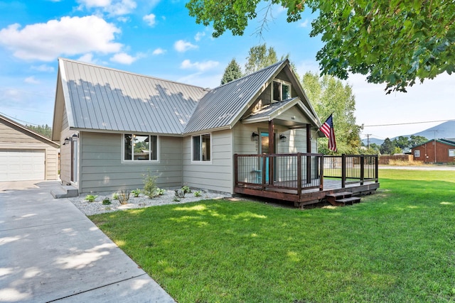 view of front facade featuring a front lawn, metal roof, a garage, a deck, and an outdoor structure