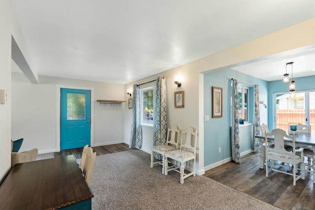 interior space featuring a healthy amount of sunlight, baseboards, and dark wood-style flooring