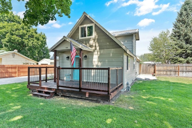 back of property featuring a fenced backyard, metal roof, a yard, and a deck