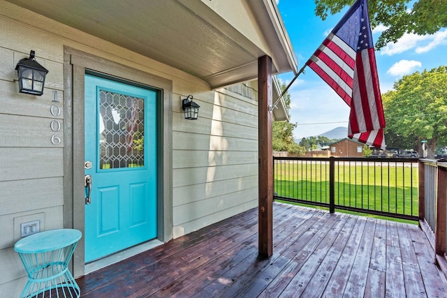 entrance to property with a wooden deck and a yard