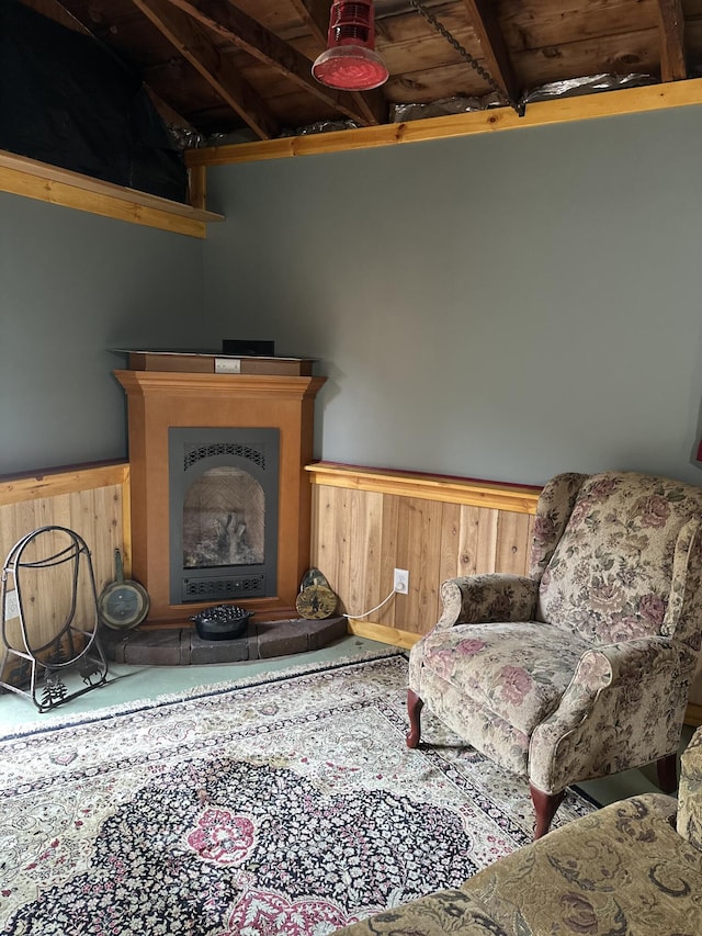 carpeted living area featuring wood walls, wainscoting, and a fireplace