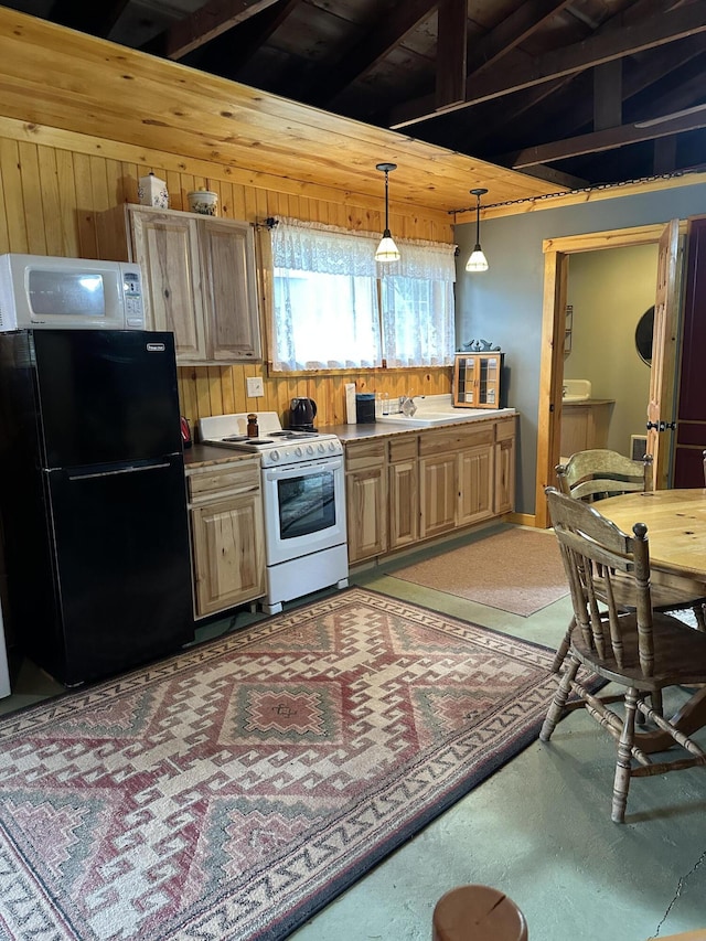 kitchen with white appliances, hanging light fixtures, wood walls, a sink, and light brown cabinets
