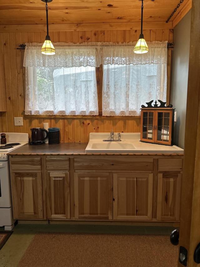 kitchen featuring white electric range oven, a sink, wood walls, and decorative light fixtures