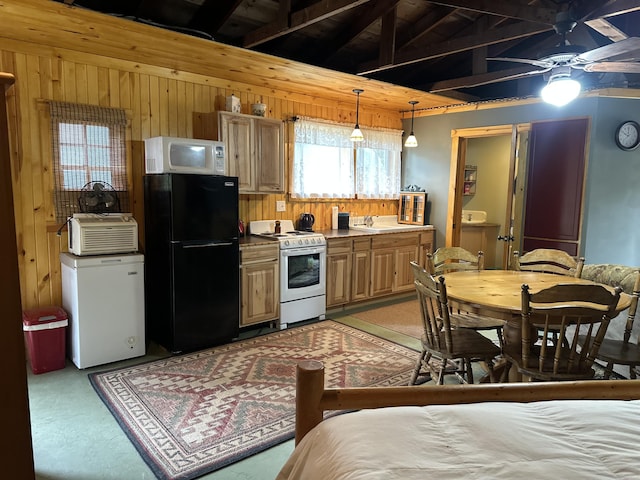 kitchen featuring white appliances, wooden walls, light carpet, a sink, and ceiling fan
