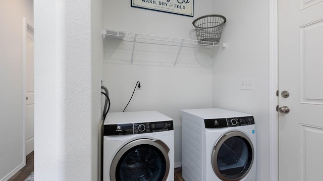 laundry room featuring separate washer and dryer and dark wood-type flooring