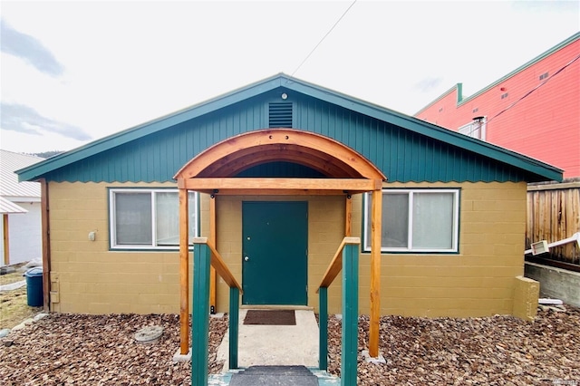 property entrance featuring fence and concrete block siding