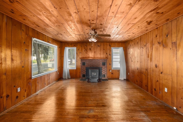 unfurnished living room featuring hardwood / wood-style flooring, ceiling fan, wood walls, and wood ceiling